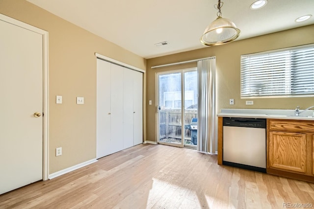 kitchen featuring sink, dishwasher, pendant lighting, and light hardwood / wood-style floors