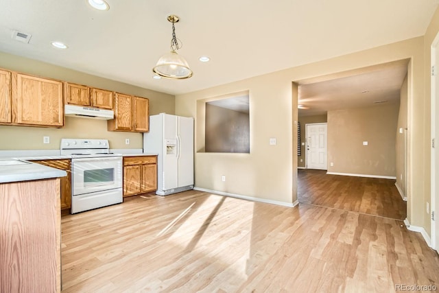 kitchen with white appliances, decorative light fixtures, and light hardwood / wood-style floors