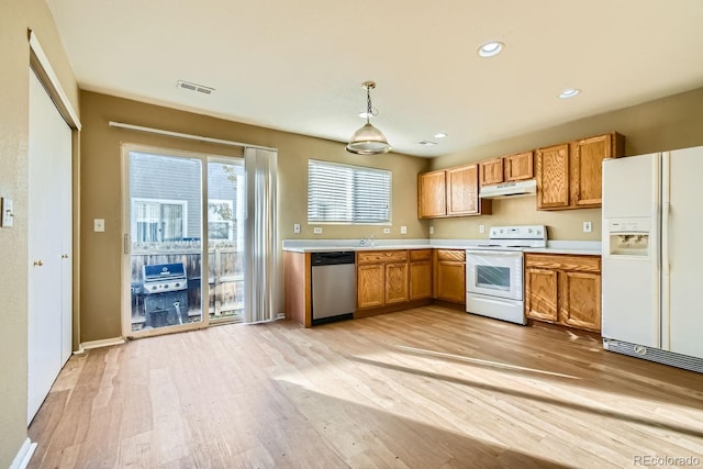 kitchen featuring decorative light fixtures, white appliances, and light hardwood / wood-style floors