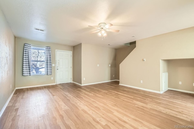 unfurnished living room with a textured ceiling, light hardwood / wood-style floors, and ceiling fan