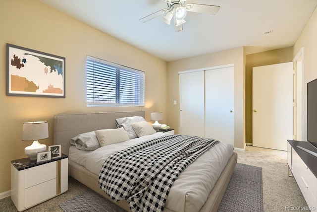 carpeted bedroom with ceiling fan and a closet