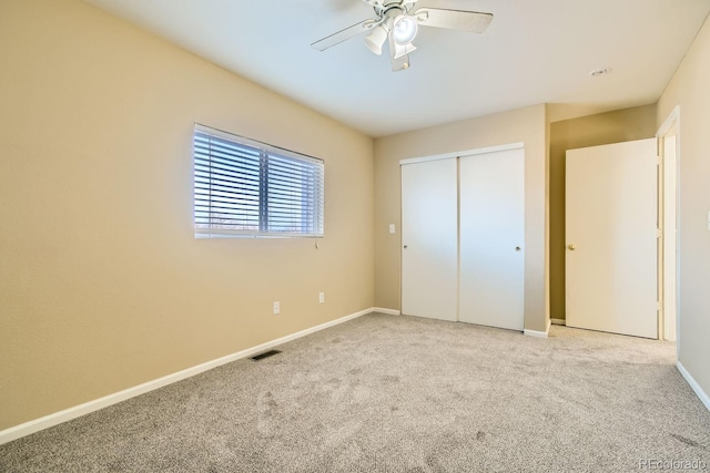 unfurnished bedroom with ceiling fan, light carpet, and a closet