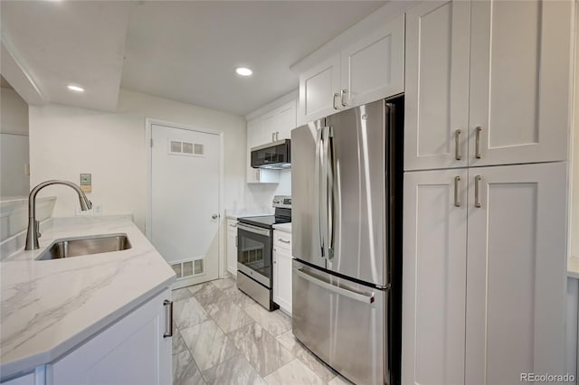 7700 W Glasgow Pl Unit 1A, Littleton, CO 80128 - kitchen featuring stainless steel appliances, light marble finish floors, recessed lighting, white cabinetry, and light stone counters