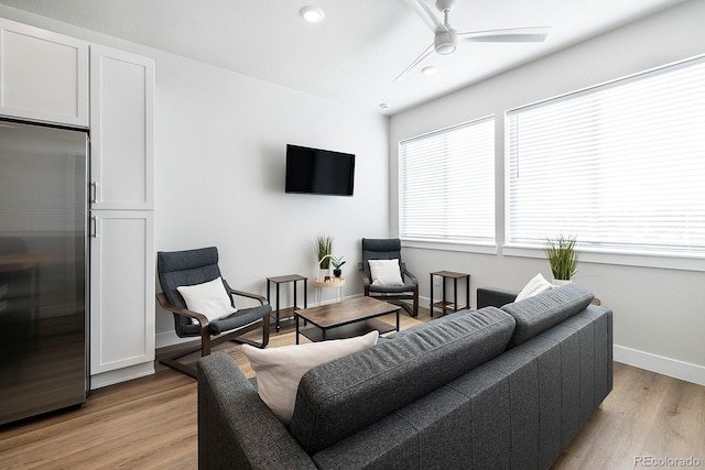 living room with ceiling fan and light hardwood / wood-style floors