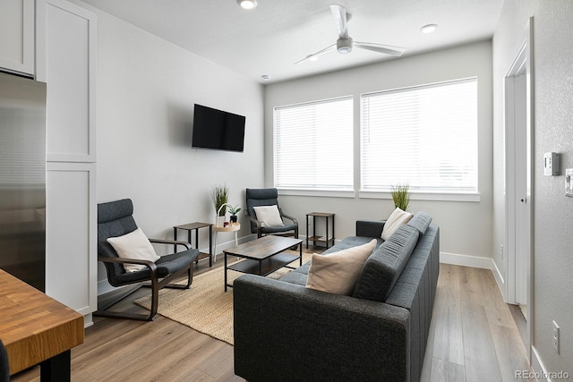 living room featuring ceiling fan and light wood-type flooring