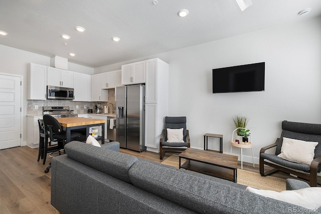 living room with sink and light hardwood / wood-style floors