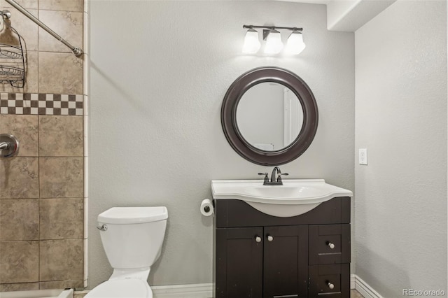 bathroom with vanity, toilet, and a shower