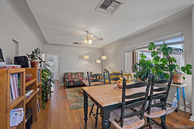 dining space featuring a ceiling fan, visible vents, baseboards, and hardwood / wood-style flooring