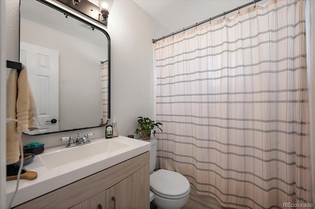 bathroom featuring a shower with shower curtain, vanity, and toilet