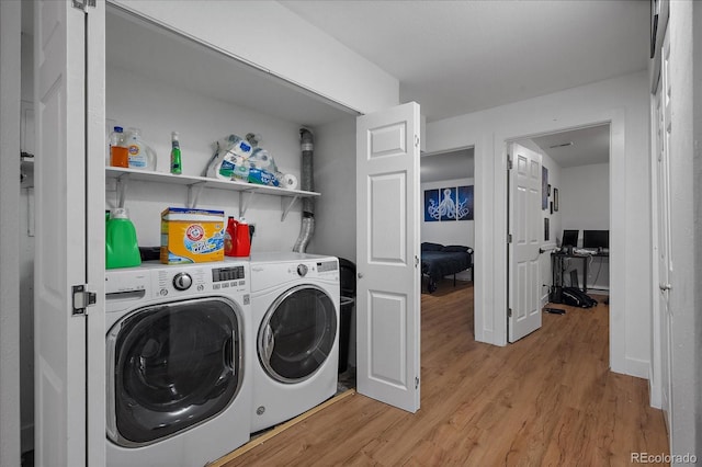 washroom featuring laundry area, independent washer and dryer, and light wood-style floors