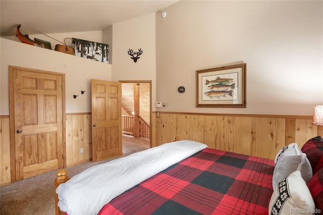 2255 Spruce Rd, Woodland Park, CO 80863 - bedroom with wainscoting, carpet flooring, wooden walls, and high vaulted ceiling