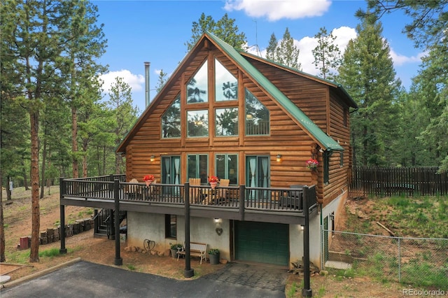2255 Spruce Rd, Woodland Park, CO 80863 - rear view of house with asphalt driveway, log siding, a wooden deck, stairs, and an attached garage