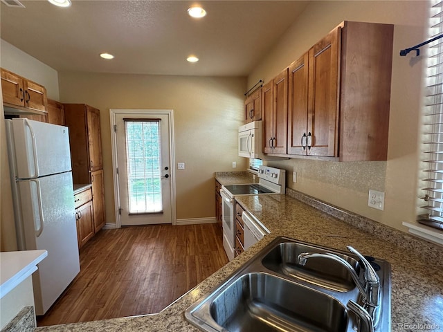 kitchen featuring white appliances, dark hardwood / wood-style floors, and sink