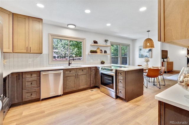 10016 Teton Ct, Lone Tree, CO 80124 - kitchen featuring appliances with stainless steel finishes, a peninsula, backsplash, light wood-type flooring, and recessed lighting
