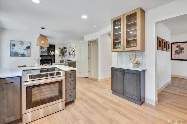 10016 Teton Ct, Lone Tree, CO 80124 - kitchen with light countertops, light wood-style floors, backsplash, a large fireplace, and glass insert cabinets