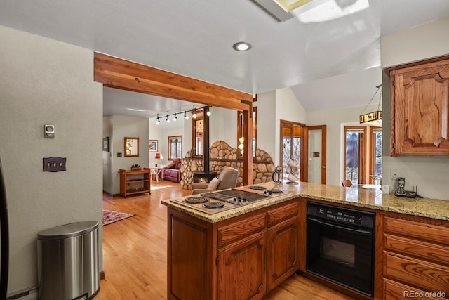 kitchen featuring oven, vaulted ceiling, light wood-type flooring, kitchen peninsula, and stainless steel gas cooktop