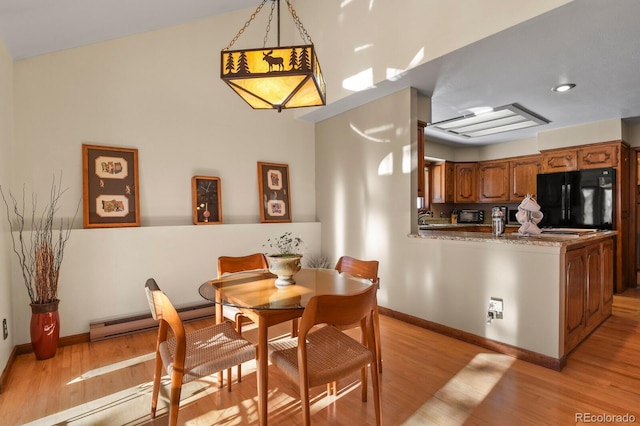 dining space featuring light hardwood / wood-style floors and a baseboard radiator