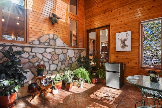 dining space featuring wooden walls and a towering ceiling