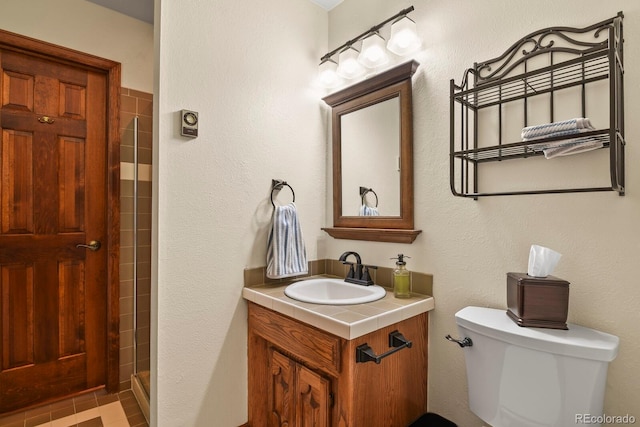 bathroom with a shower with door, vanity, and toilet