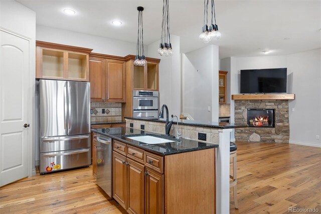 4364 Chateau Ridge Ln, Castle Rock, CO 80108 - kitchen with appliances with stainless steel finishes, brown cabinetry, tasteful backsplash, a center island with sink, and recessed lighting