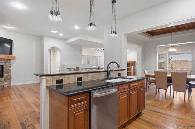 4364 Chateau Ridge Ln, Castle Rock, CO 80108 - kitchen featuring stainless steel dishwasher, brown cabinets, light wood finished floors, a kitchen island with sink, and recessed lighting
