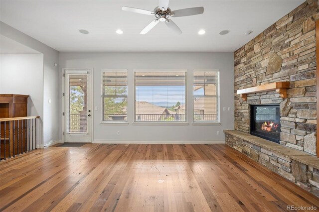 4364 Chateau Ridge Ln, Castle Rock, CO 80108 - unfurnished living room with a stone fireplace, wood-type flooring, ceiling fan, and recessed lighting