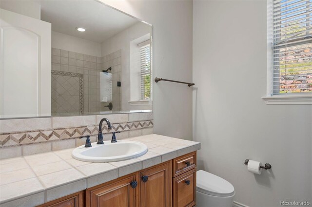 4364 Chateau Ridge Ln, Castle Rock, CO 80108 - bathroom featuring vanity, tiled shower, healthy amount of natural light, and decorative backsplash