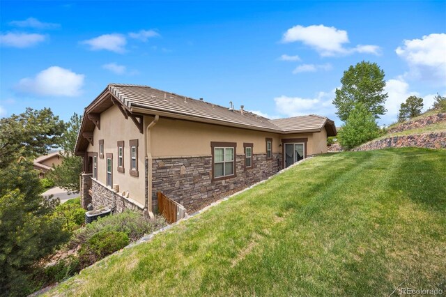 4364 Chateau Ridge Ln, Castle Rock, CO 80108 - back of house featuring stone siding, stucco siding, and a lawn
