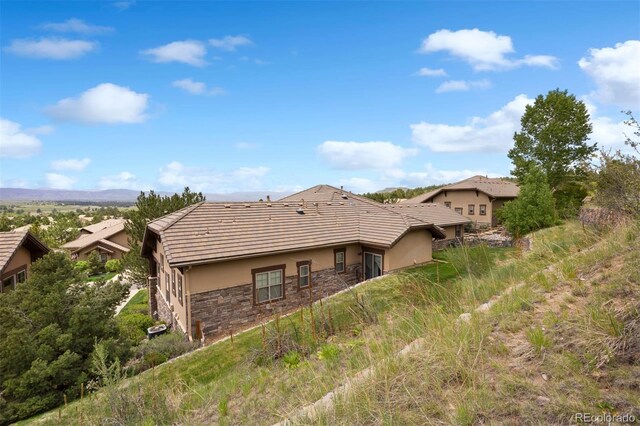 4364 Chateau Ridge Ln, Castle Rock, CO 80108 - back of house with stucco siding, stone siding, and a tiled roof