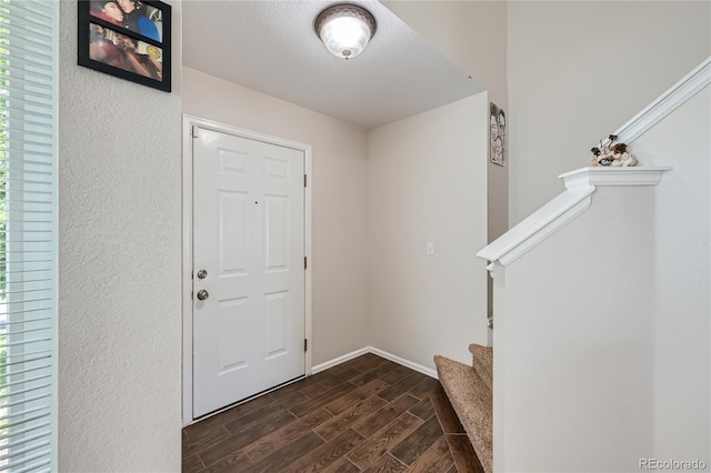 entrance foyer with wood tiled floor, stairs, and baseboards