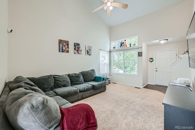 living room with baseboards, visible vents, ceiling fan, dark colored carpet, and high vaulted ceiling