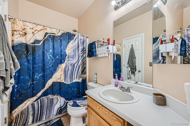 bathroom featuring toilet, a textured wall, a shower with shower curtain, and vanity