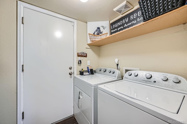 clothes washing area with laundry area, visible vents, washer and clothes dryer, and a textured ceiling