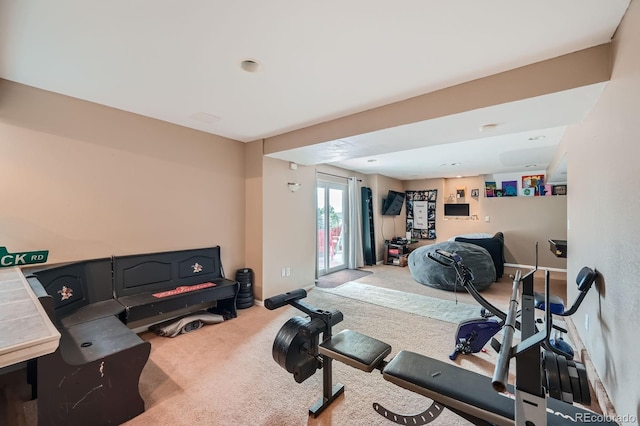 exercise room with baseboards and carpet flooring