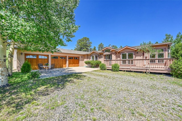 153 Gold Run Trl, Idaho Springs, CO 80452 - back of property with an attached garage, a deck, and a patio