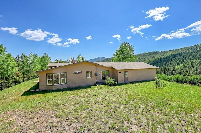 153 Gold Run Trl, Idaho Springs, CO 80452 - rear view of house with a wooded view and a lawn