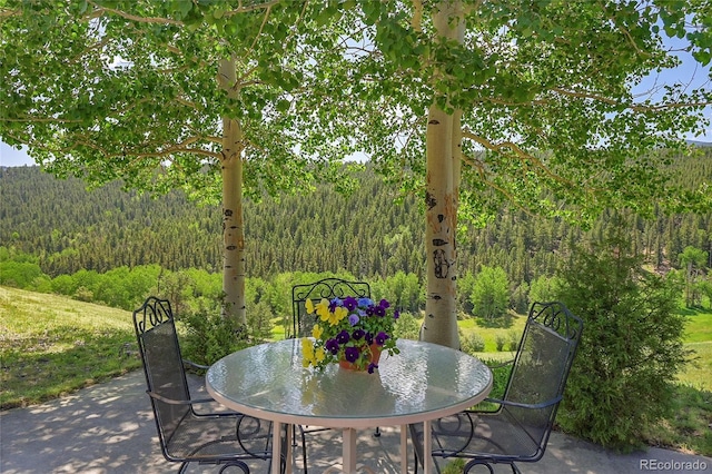 153 Gold Run Trl, Idaho Springs, CO 80452 - view of patio featuring a wooded view and outdoor dining space