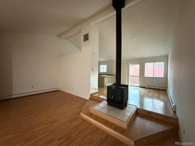 6921 S Bryant St, Littleton, CO 80120 - unfurnished living room with wood finished floors, a wood stove, and a baseboard heating unit