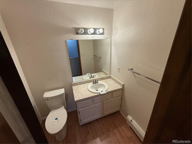 6921 S Bryant St, Littleton, CO 80120 - half bath featuring a baseboard radiator, wood finished floors, toilet, and vanity