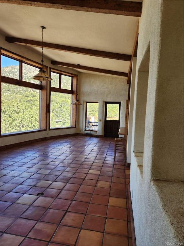 unfurnished living room with high vaulted ceiling, beamed ceiling, and tile patterned floors