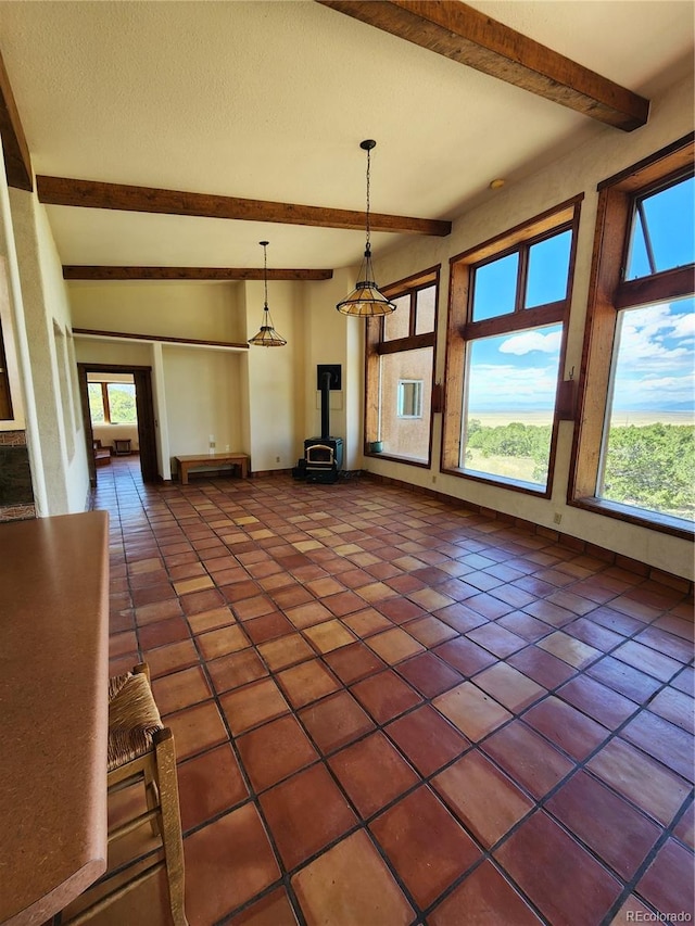 unfurnished living room with lofted ceiling with beams and dark tile patterned flooring