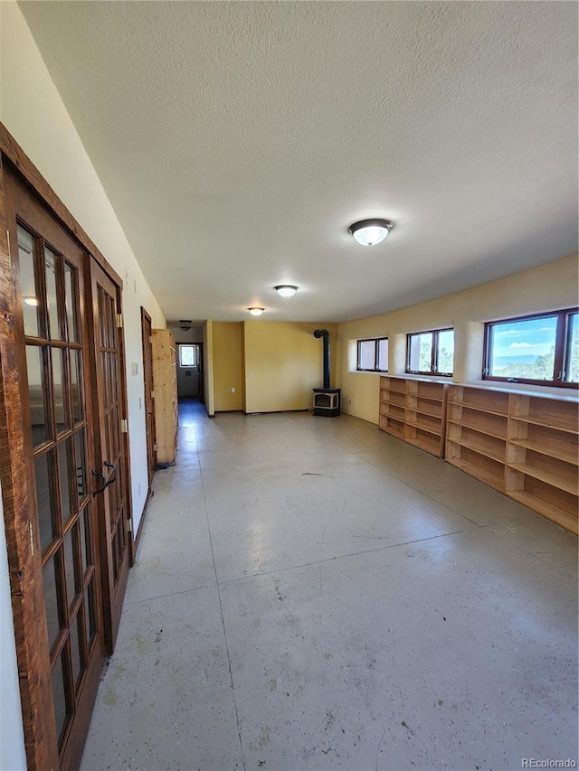 empty room featuring a textured ceiling and a wood stove