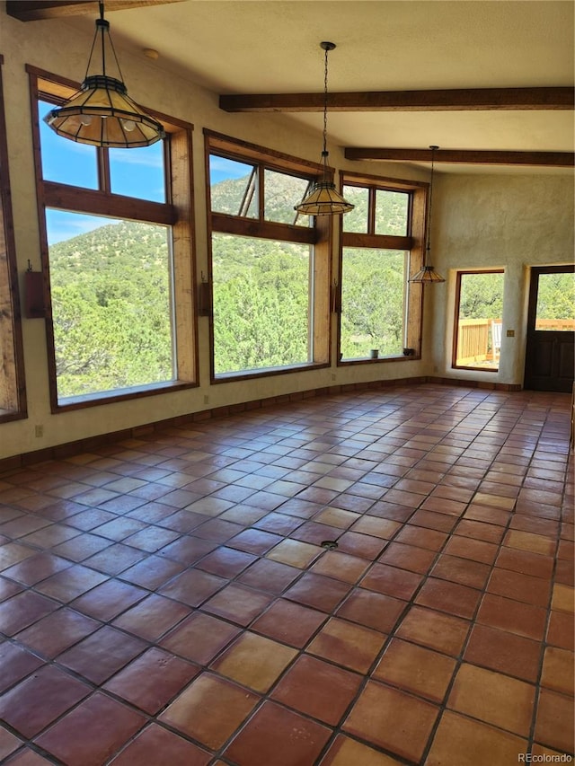 interior space with lofted ceiling with beams and dark tile patterned floors