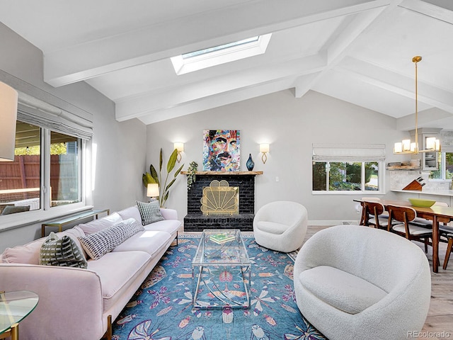 living room featuring vaulted ceiling with skylight, an inviting chandelier, wood-type flooring, and a brick fireplace