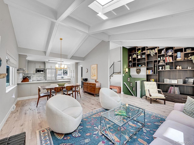 living room featuring an inviting chandelier, lofted ceiling with skylight, and light hardwood / wood-style floors