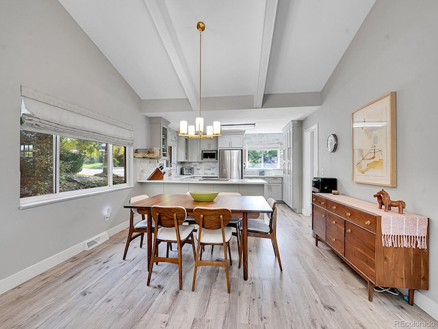 dining space featuring sink, a chandelier, light hardwood / wood-style flooring, and vaulted ceiling with beams