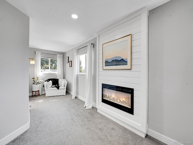 unfurnished living room featuring carpet floors and a large fireplace