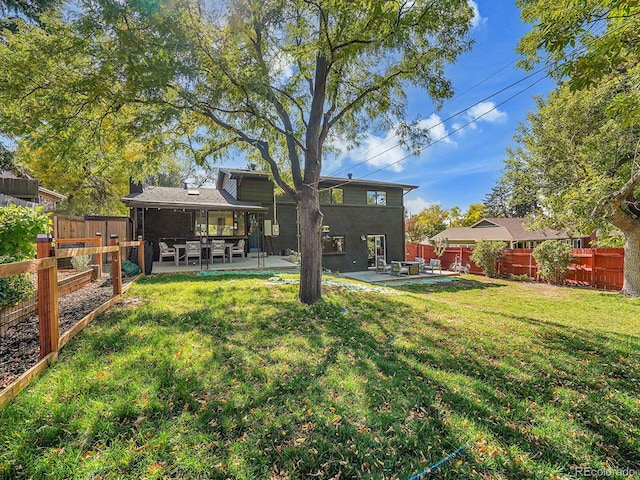 back of house with a yard and a patio