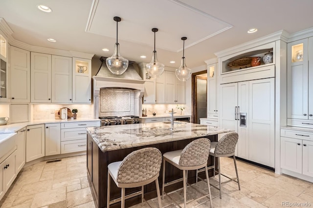 kitchen with a kitchen breakfast bar, stone tile floors, tasteful backsplash, and recessed lighting