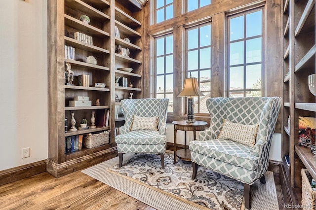 sitting room with wood finished floors, a healthy amount of sunlight, and baseboards